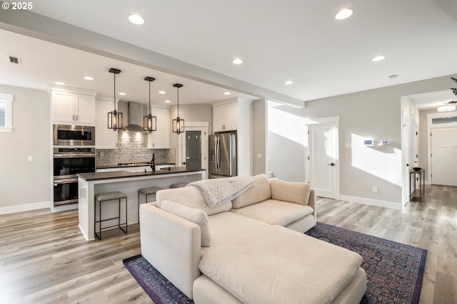 living room with sink and light wood-type flooring