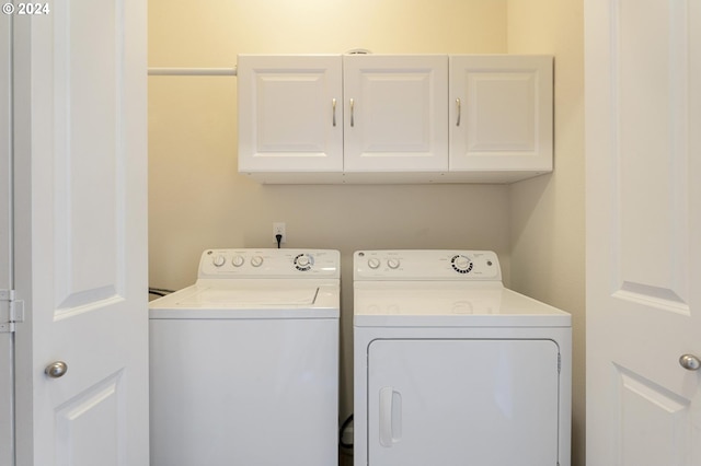 laundry room with washing machine and dryer and cabinets