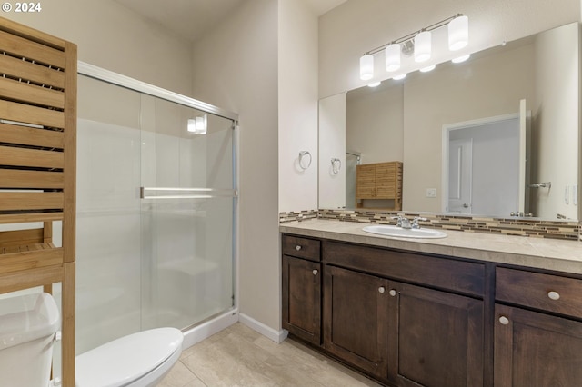 bathroom with vanity, tasteful backsplash, tile patterned flooring, toilet, and a shower with door