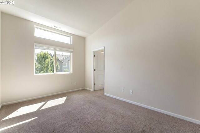 empty room featuring high vaulted ceiling and light carpet