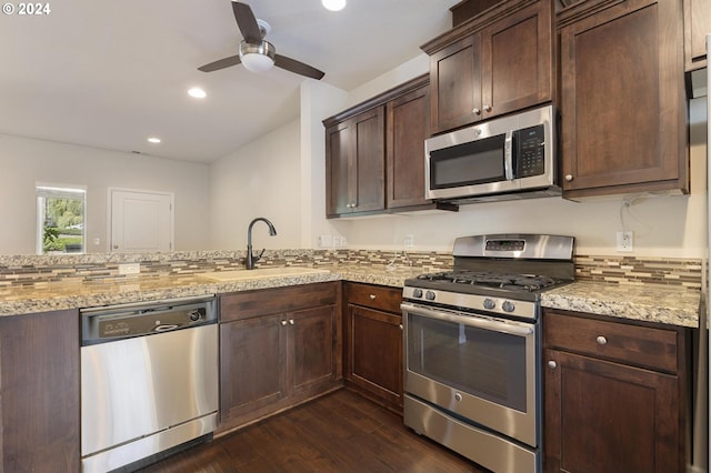 kitchen with sink, dark wood-type flooring, light stone countertops, ceiling fan, and stainless steel appliances