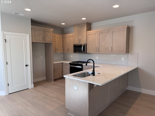 kitchen with sink, kitchen peninsula, light hardwood / wood-style flooring, decorative backsplash, and black electric range oven