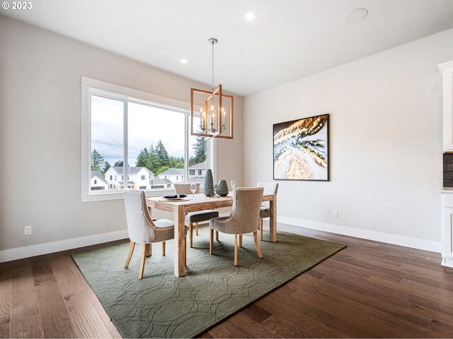 dining space featuring dark hardwood / wood-style floors and an inviting chandelier