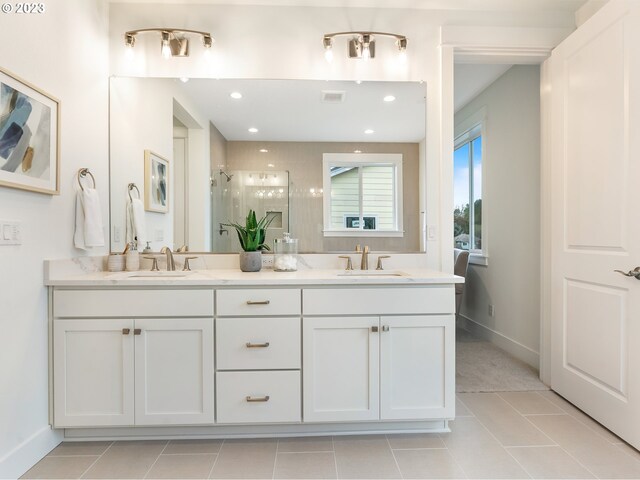 bathroom featuring tile patterned flooring, vanity, and a shower with door