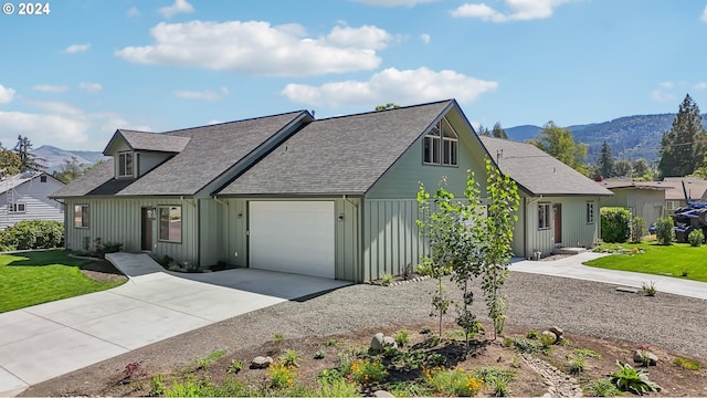 view of front of house featuring board and batten siding, a mountain view, driveway, and a garage