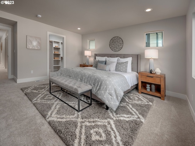 bedroom with a walk in closet, a closet, and carpet floors