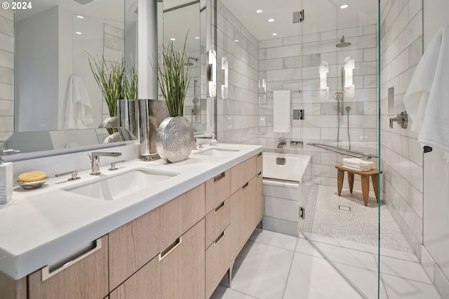 bathroom featuring a shower stall, tile walls, double vanity, and a sink