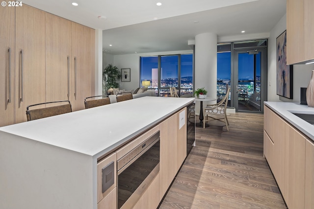 kitchen with light brown cabinetry, modern cabinets, dark wood-type flooring, and light countertops