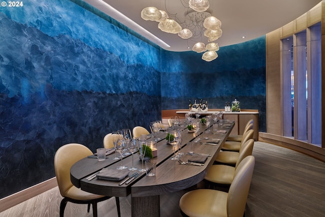 dining space featuring a chandelier, baseboards, and wood finished floors