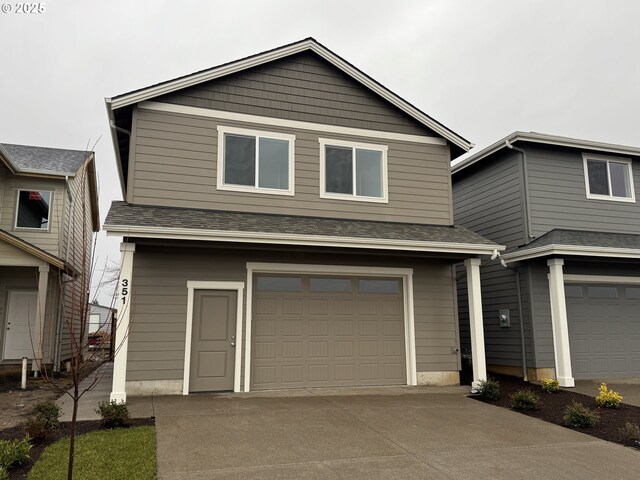 view of front facade with driveway, a shingled roof, and an attached garage