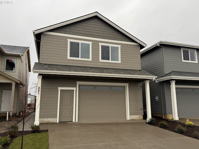 view of front of house with a garage, roof with shingles, and concrete driveway