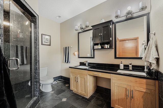 bathroom featuring a shower with door, vanity, and toilet