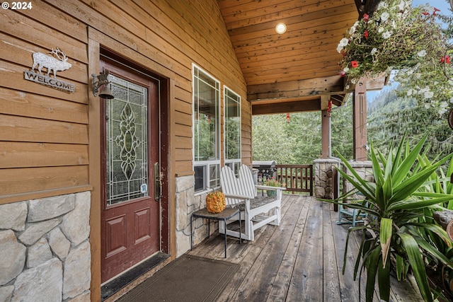 wooden terrace with a grill and covered porch