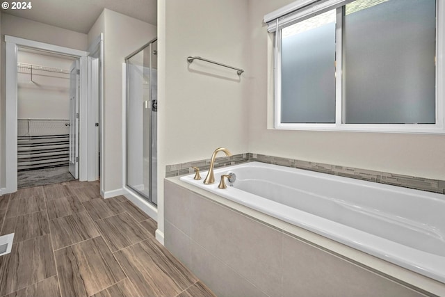 bathroom featuring visible vents, a garden tub, a spacious closet, and a shower stall