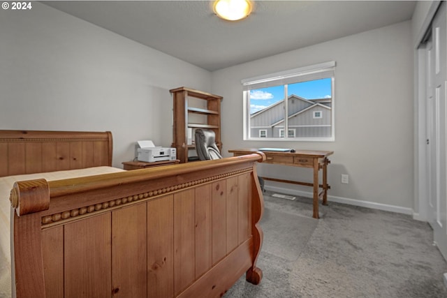 bedroom with baseboards and light colored carpet