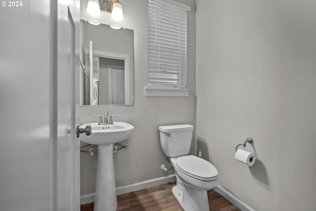 bathroom with wood finished floors, toilet, and baseboards