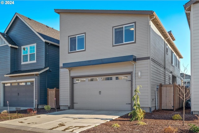 view of front of property featuring a garage, driveway, and fence