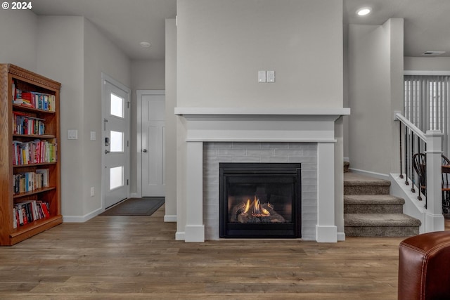 living room featuring light hardwood / wood-style flooring and a tiled fireplace