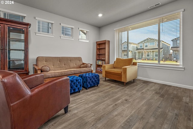 living area with recessed lighting, visible vents, baseboards, and wood finished floors