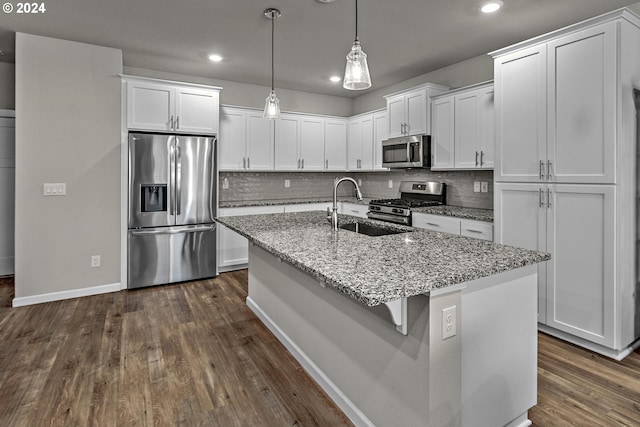 kitchen featuring sink, white cabinets, decorative light fixtures, and appliances with stainless steel finishes