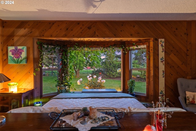 bedroom featuring wood walls and a textured ceiling