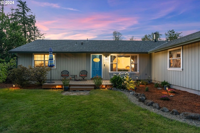 view of front of property with a deck and a lawn