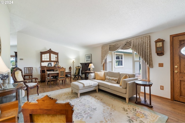 living room featuring light wood-type flooring and a textured ceiling