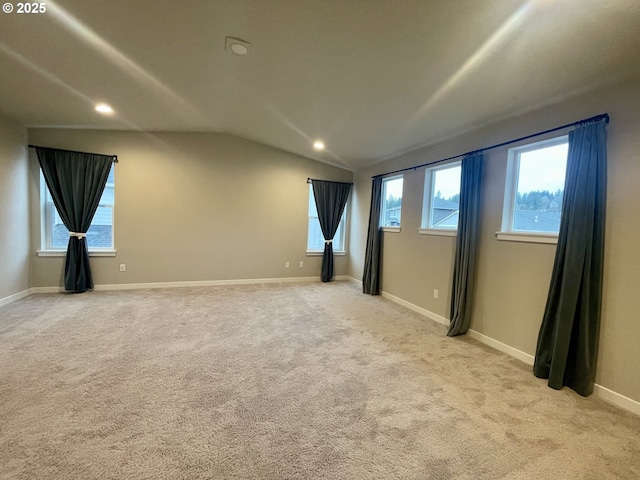 spare room featuring lofted ceiling, recessed lighting, baseboards, and light carpet