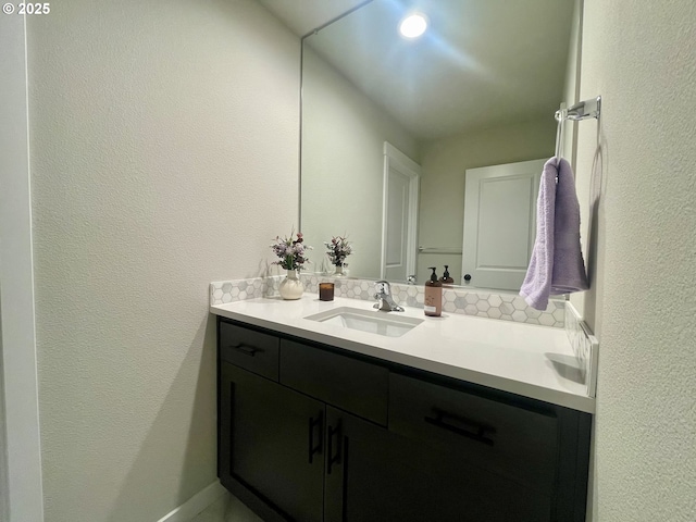 bathroom with vanity and a textured wall