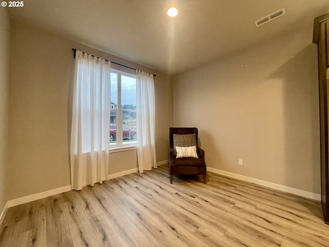 unfurnished room with light wood-style floors, visible vents, and baseboards