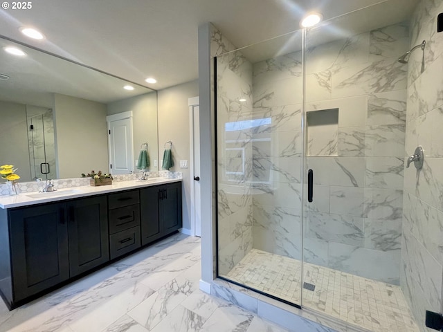 full bath with a marble finish shower, double vanity, recessed lighting, a sink, and marble finish floor