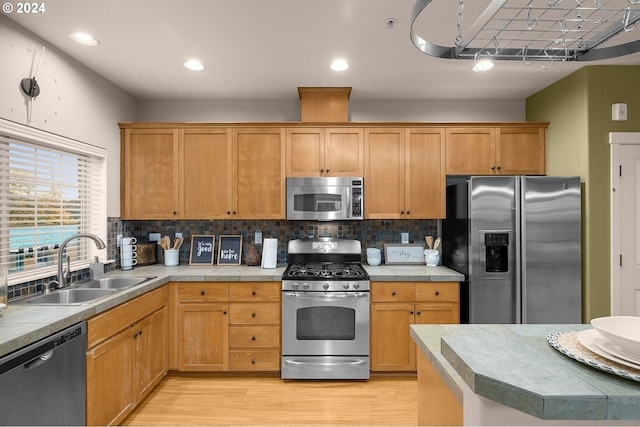 8844 NE Brentford Way, Hillsboro, OR 97006 - kitchen with backsplash, sink, light hardwood / wood-style floors, and appliances with stainless steel finishes