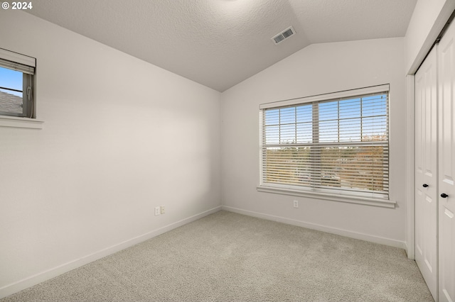 8844 NE Brentford Way, Hillsboro, OR 97006 - unfurnished room featuring light colored carpet, a textured ceiling, and vaulted ceiling