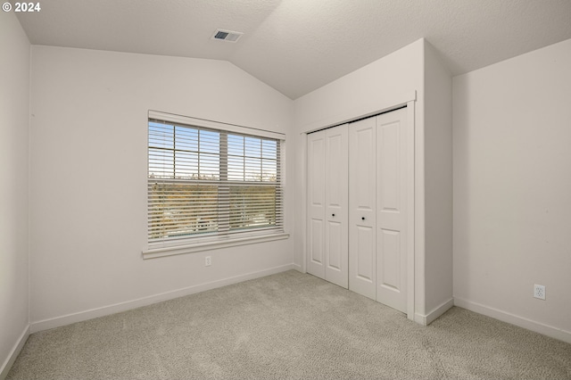8844 NE Brentford Way, Hillsboro, OR 97006 - unfurnished bedroom featuring light carpet, vaulted ceiling, and a closet