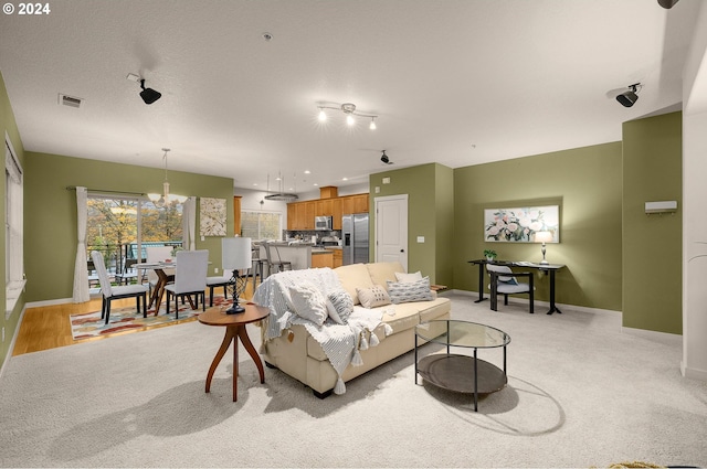8844 NE Brentford Way, Hillsboro, OR 97006 - carpeted living room with a textured ceiling and a notable chandelier