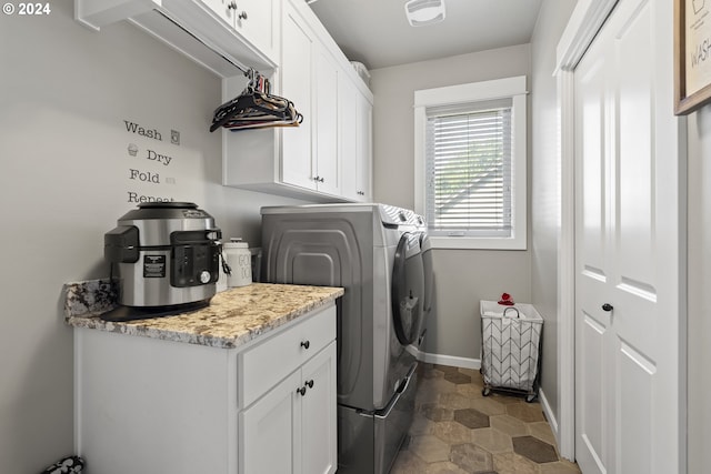 clothes washing area with cabinets and independent washer and dryer