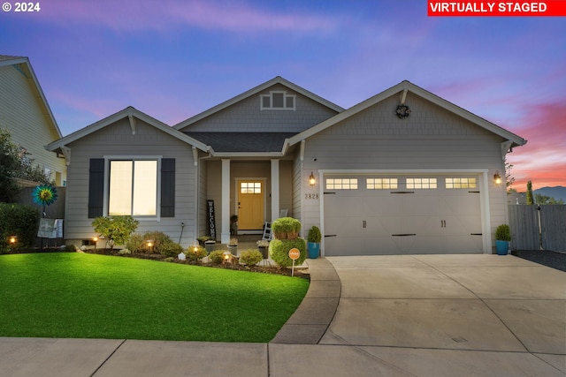 view of front of home with a garage and a lawn