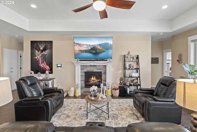 living room featuring ceiling fan, wood-type flooring, and a fireplace