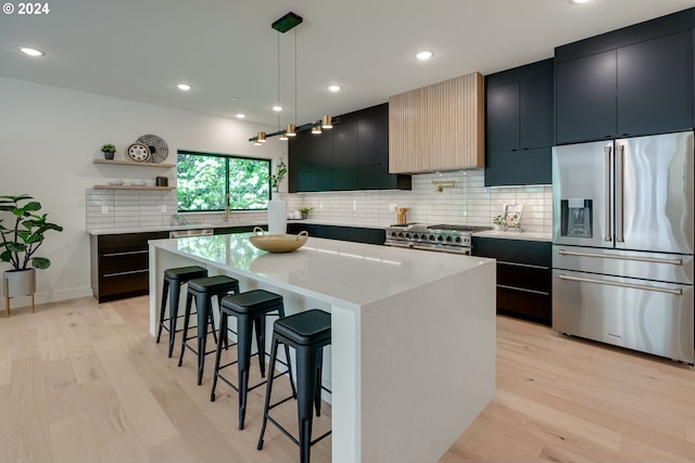 kitchen featuring a center island, light hardwood / wood-style flooring, pendant lighting, and high end appliances