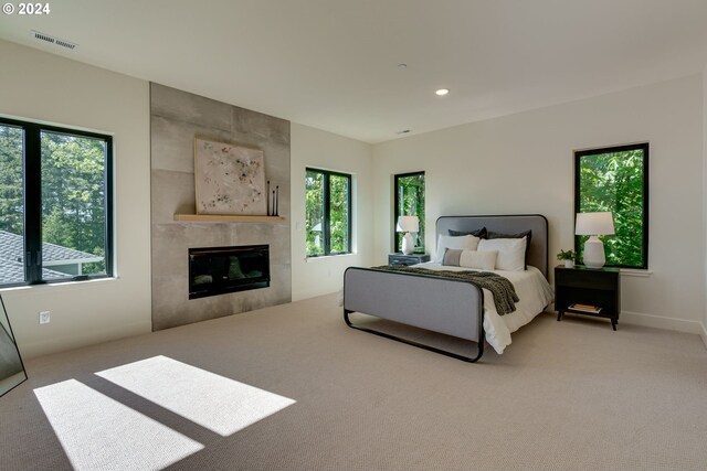 carpeted bedroom with a tile fireplace