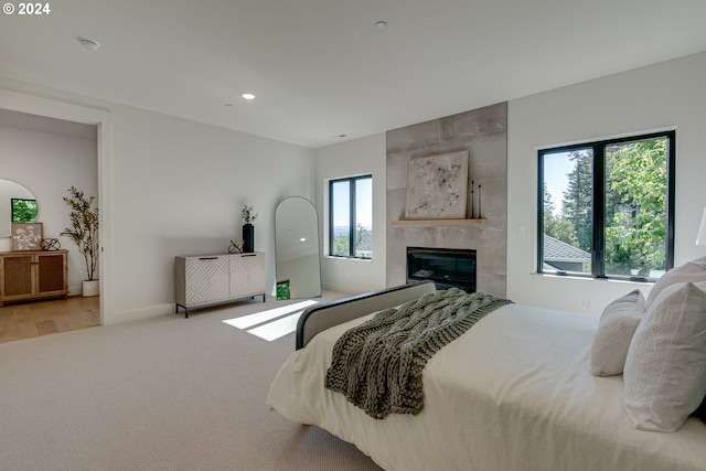 carpeted bedroom with a tile fireplace