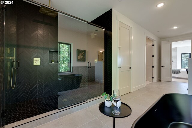 bathroom with a wealth of natural light, tile patterned flooring, and a shower with shower door