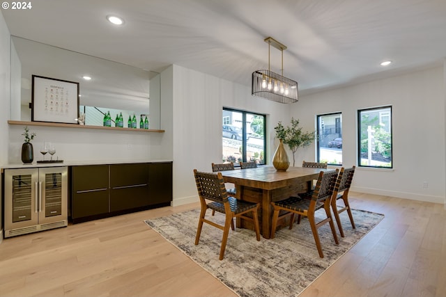 dining space featuring plenty of natural light, beverage cooler, and light wood-type flooring