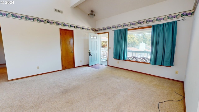 carpeted empty room with lofted ceiling with beams