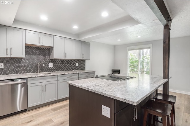kitchen with dishwasher, a sink, stovetop with downdraft, gray cabinets, and recessed lighting