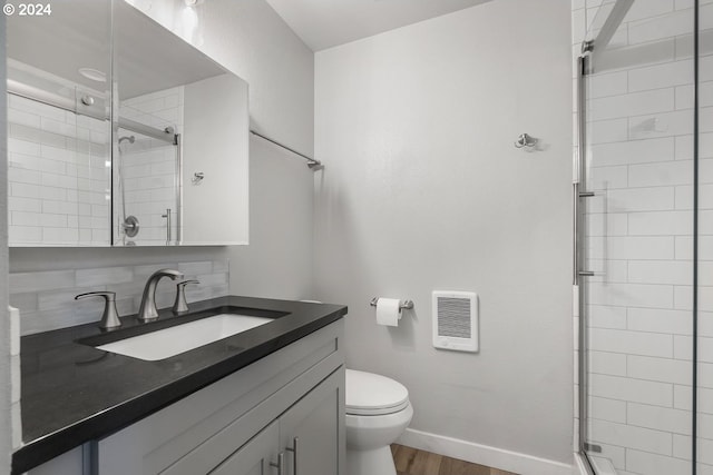 bathroom with vanity, wood-type flooring, a shower with shower door, and toilet