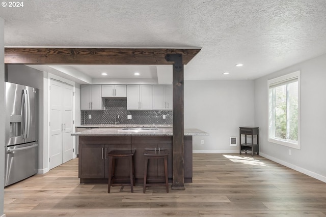 kitchen featuring appliances with stainless steel finishes, light wood finished floors, baseboards, recessed lighting, and a textured ceiling