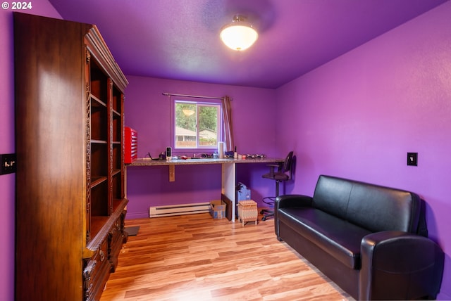 sitting room featuring baseboard heating and light hardwood / wood-style flooring