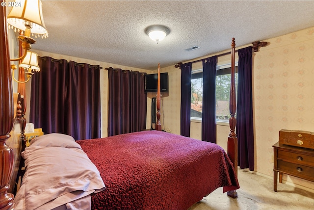 bedroom with light carpet and a textured ceiling