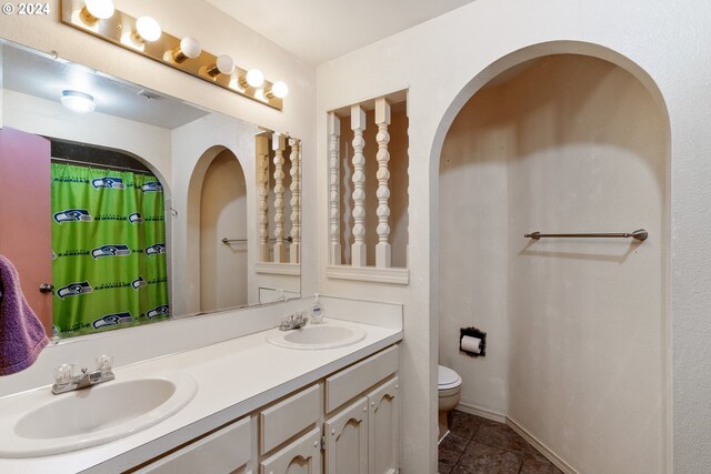 bathroom featuring tile patterned floors, vanity, and toilet